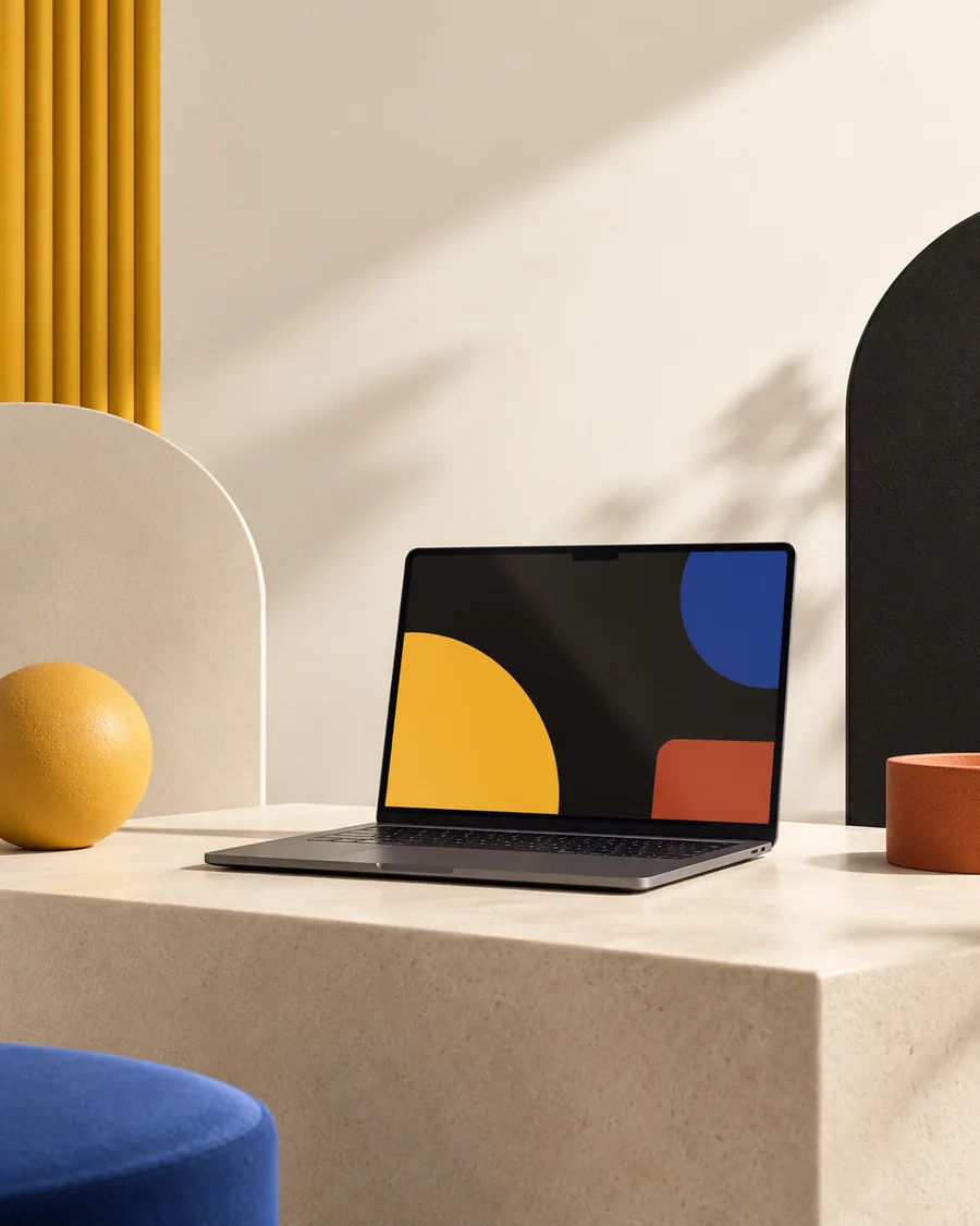 Illustration av en öppen laptop på en stenpelare bland geometriska former i saffran, kobolt och terrakotta